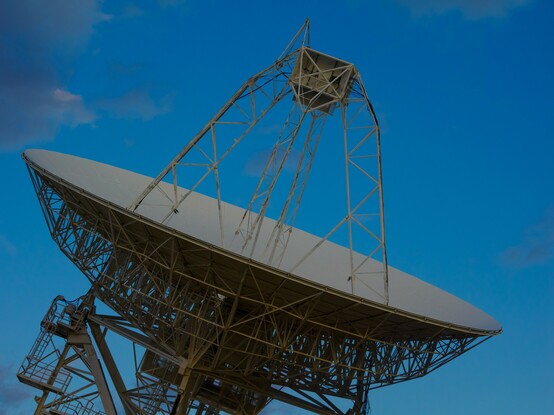 A close up of the center of a radio telescope during the daytime.