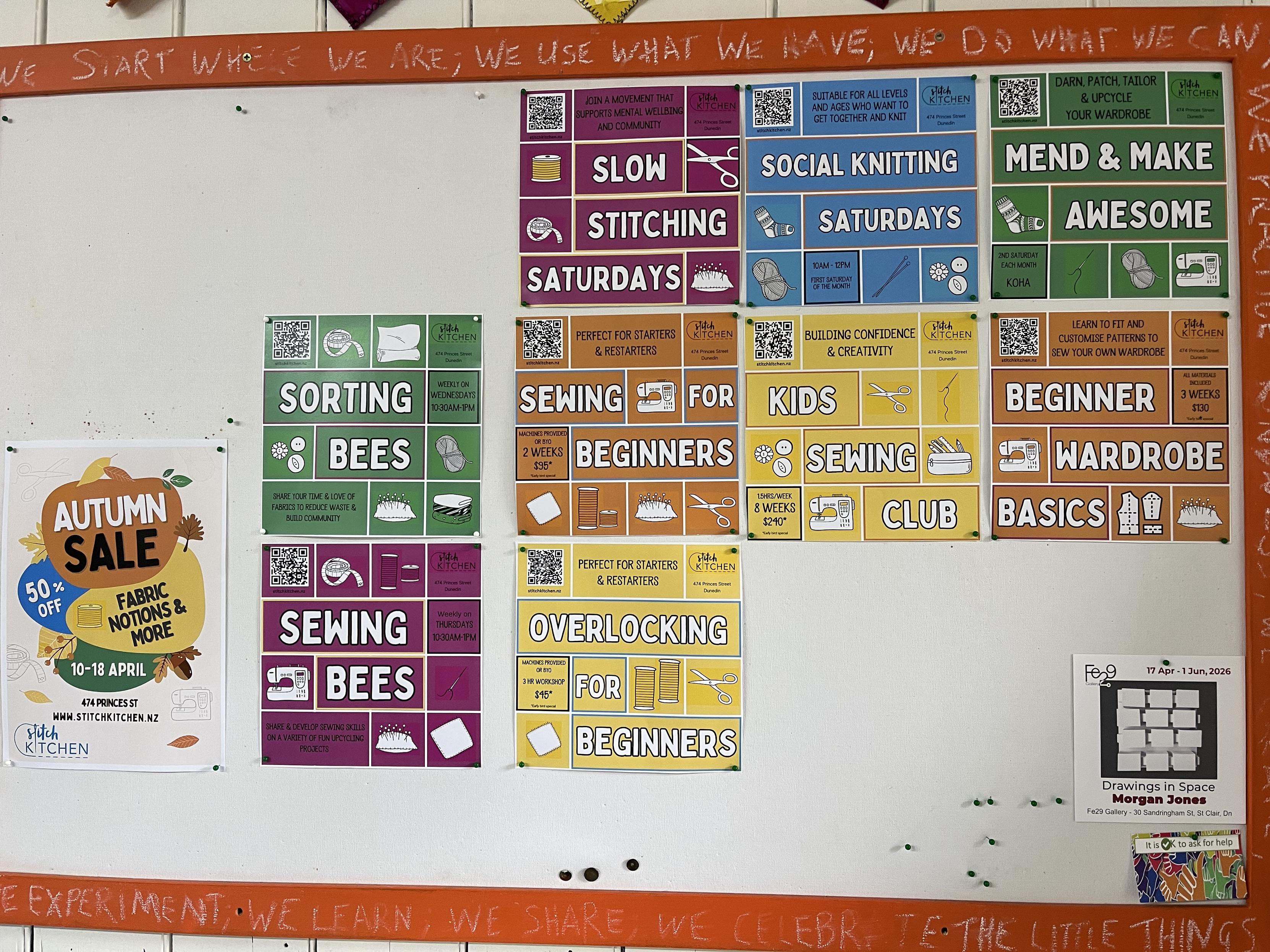 The Stitch Kitchen notice board with posters for various events. They include Autumn Sale, Sorting Bees, Slow Stitching Saturdays, Social Knitting Saturdays, Mend & Make Awesome, Sewing for Beginners, Kids Sewing Club, Beginner Wardrobe Basics, Sewing Bees, Overlocking for Beginners