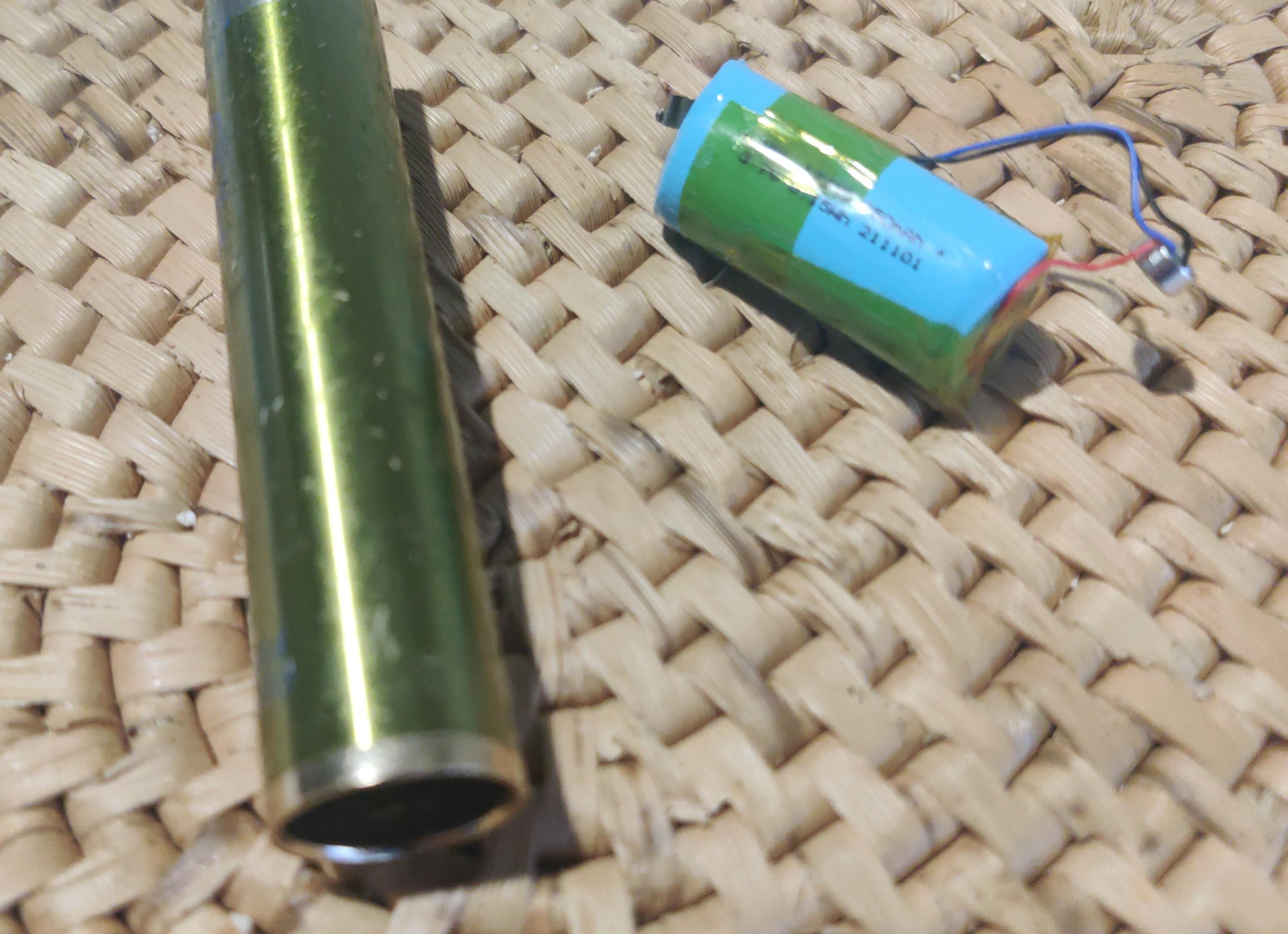 The remains of a disassembled vape including its metal tube and a blue cylindrical lithium battery. I'm not good with small battery numbers, but it would be an 18350 or similar.