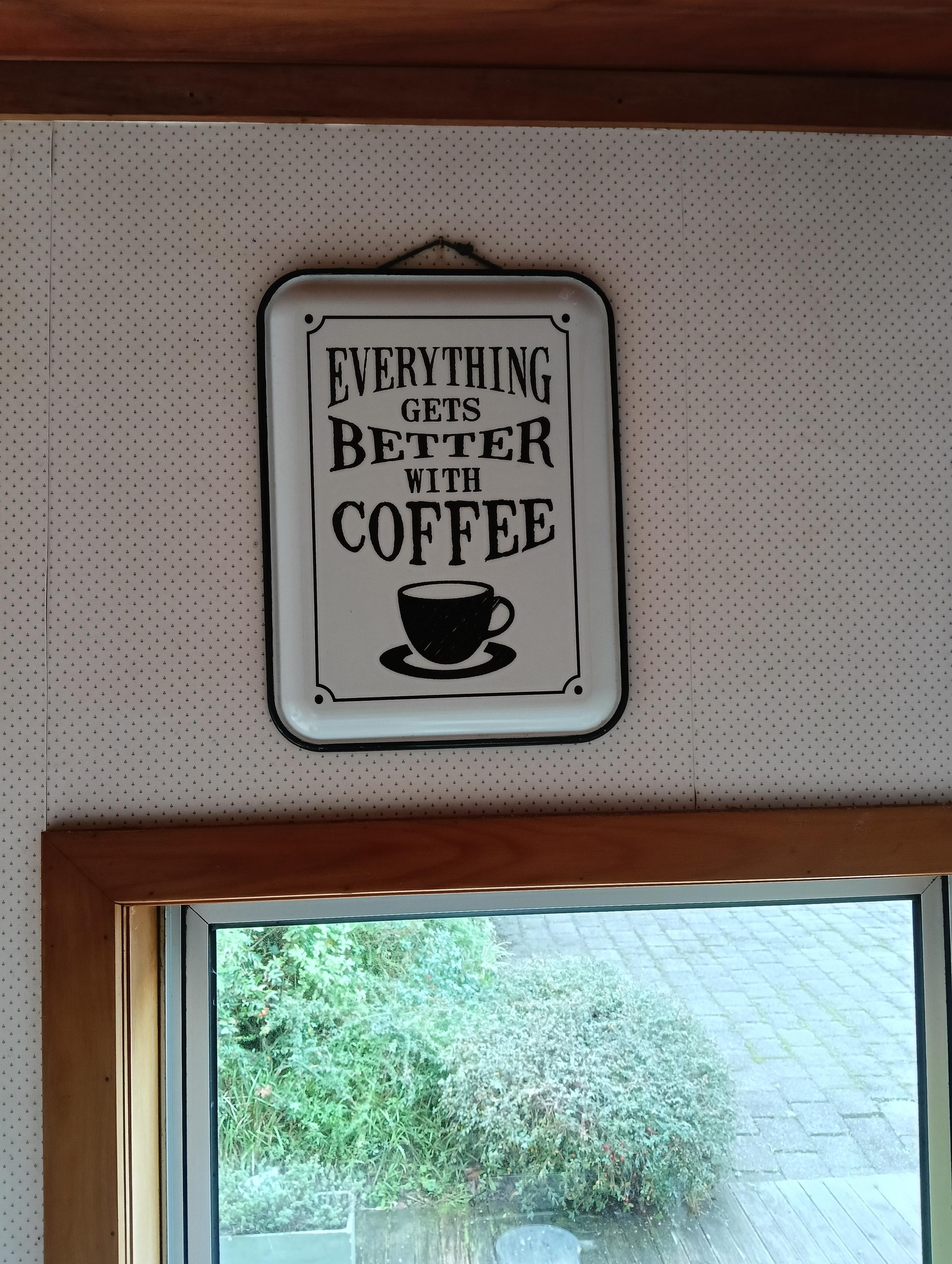 A white enamel sign, with the text of the toot in black letter above a black coffee cup. It is styled as an old style outdoor sign