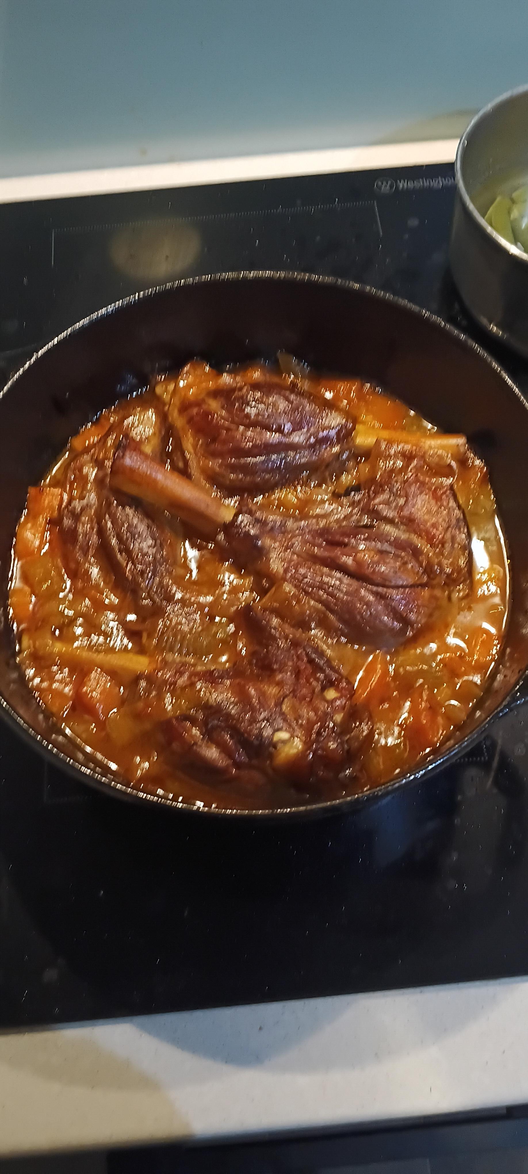 The cooked lamb shanks in the pot