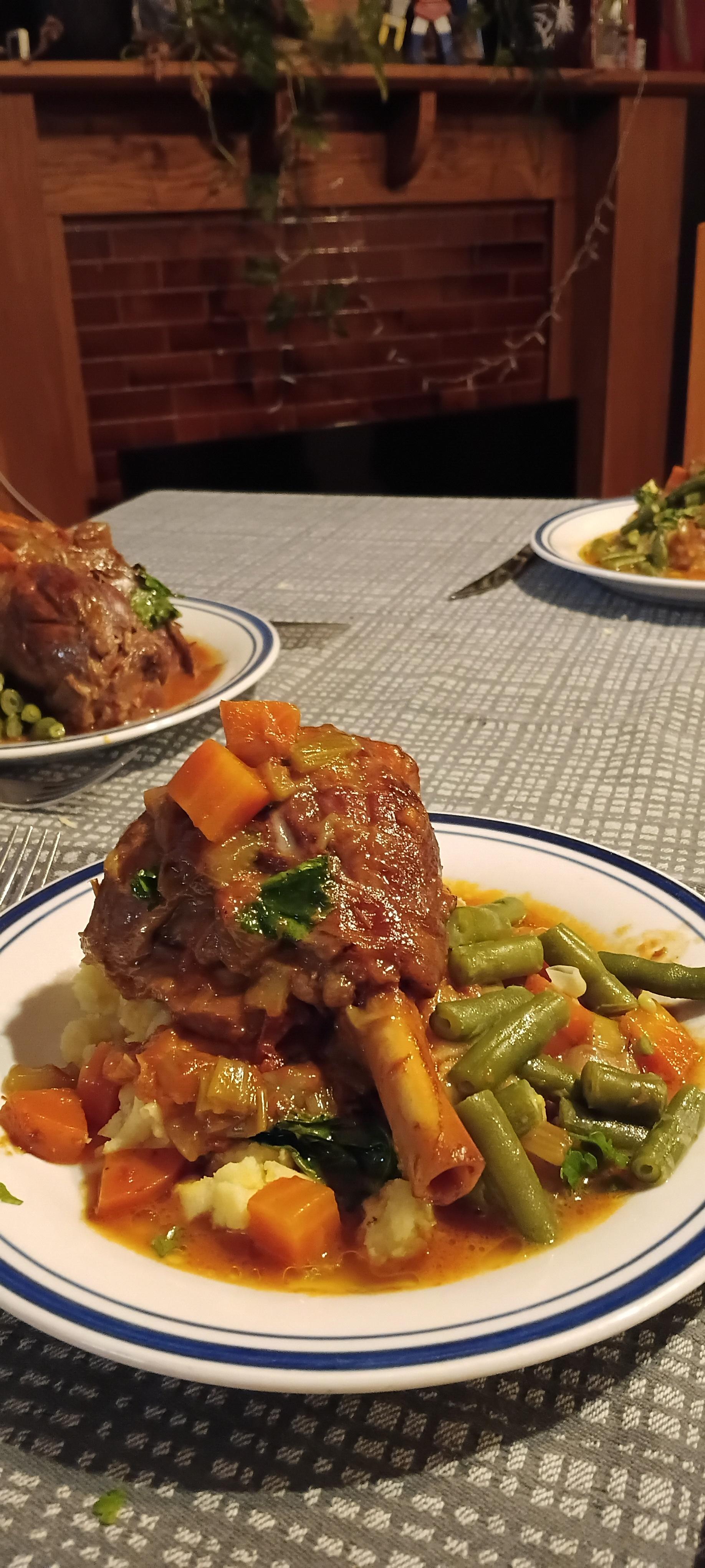 The lamb shanks served onto plates.