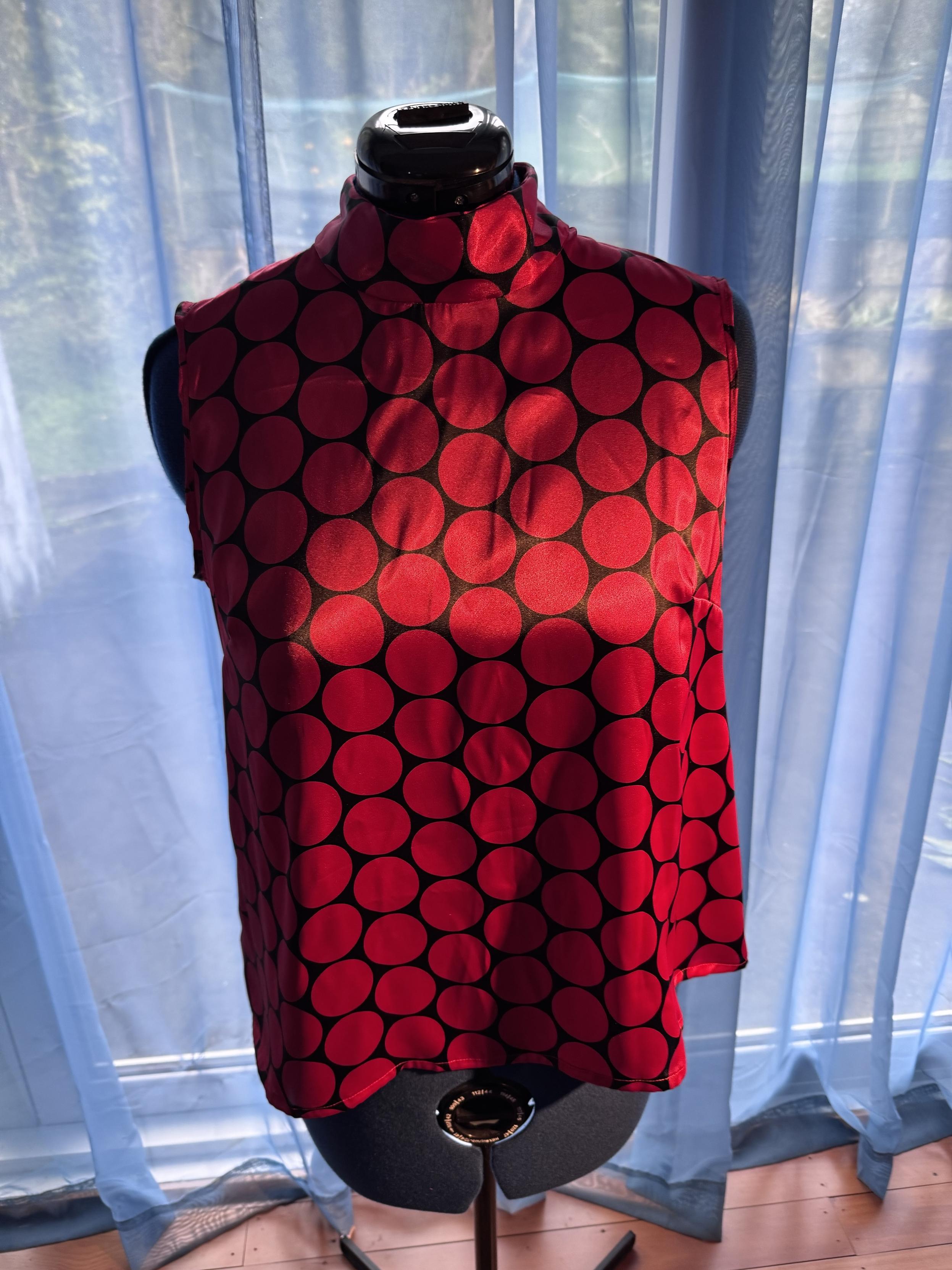 Provided by @altbot, generated privately and locally using Gemma4:26b

@ygathgoch A sleeveless, shiny red top with large dark polka dots is displayed on a black mannequin. The fabric has a satin-like sheen and features a pattern of large, dark circular dots across its entire surface. The garment has a high neckline and a vertical seam running down the center back. It is positioned in front of light blue, sheer curtains that are backlit by bright daylight. A portion of a wooden floor is visible at the bottom of the frame.
―
A close-up photograph of red and black patterned fabric featuring two large, glittery buttons. The fabric has wide, wavy black shapes over a deep red base with a slight sheen. Two circular, translucent buttons are arranged vertically, each containing bright pinkish-red glitter inside.
―
A sleeveless, high-necked top is displayed on a black mannequin. The garment is red with large, black polka dots arranged in a pattern across its entire surface. Behind the mannequin, sheer light blue curtains hang in front of a window, casting sunlight and shadows across the top. A small portion of a wooden floor is visible at the bottom of the image.

🌱 Energy used: 0.888 Wh