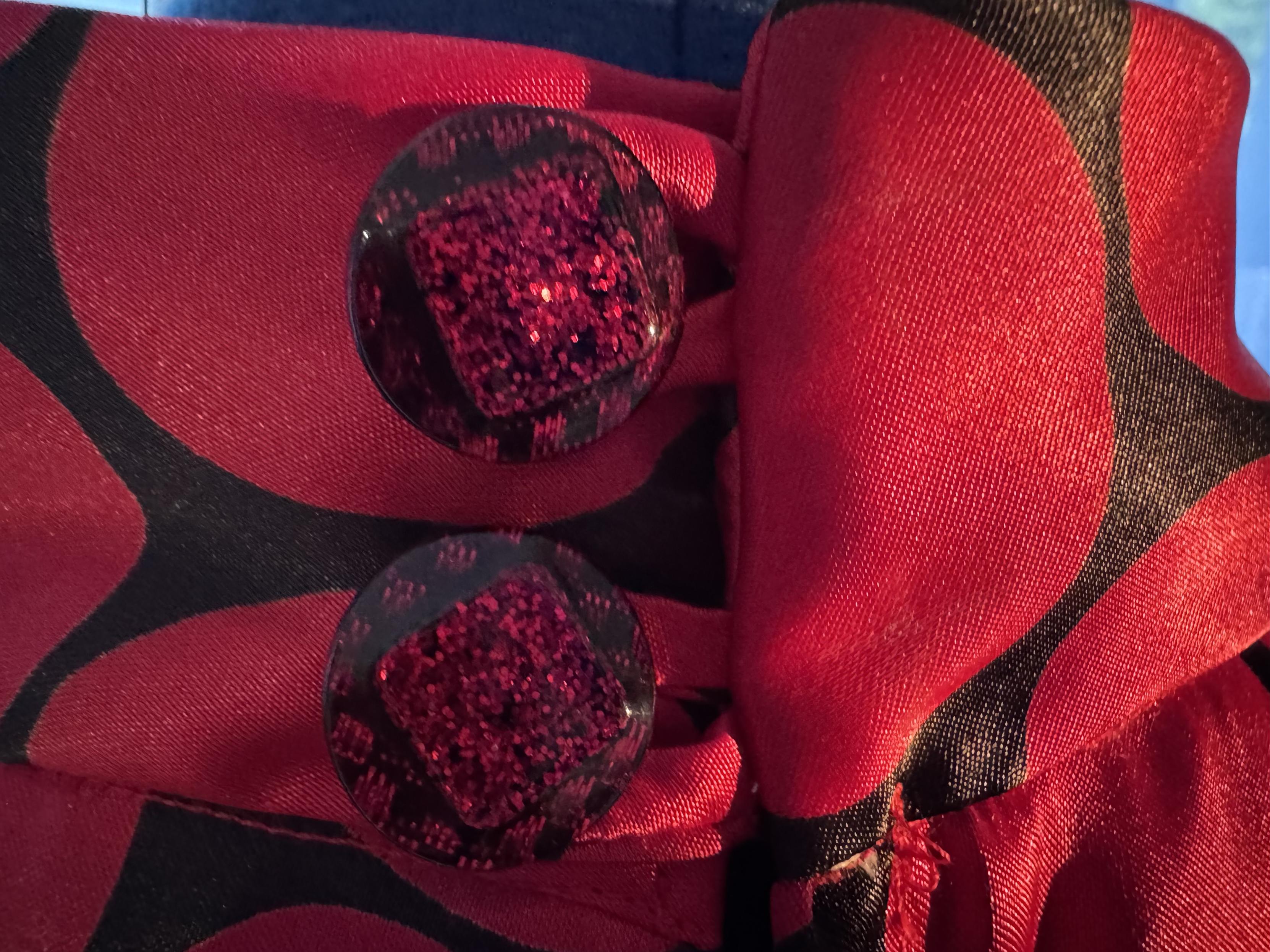 Provided by @altbot, generated privately and locally using Gemma4:26b

@ygathgoch A sleeveless, shiny red top with large dark polka dots is displayed on a black mannequin. The fabric has a satin-like sheen and features a pattern of large, dark circular dots across its entire surface. The garment has a high neckline and a vertical seam running down the center back. It is positioned in front of light blue, sheer curtains that are backlit by bright daylight. A portion of a wooden floor is visible at the bottom of the frame.
―
A close-up photograph of red and black patterned fabric featuring two large, glittery buttons. The fabric has wide, wavy black shapes over a deep red base with a slight sheen. Two circular, translucent buttons are arranged vertically, each containing bright pinkish-red glitter inside.
―
A sleeveless, high-necked top is displayed on a black mannequin. The garment is red with large, black polka dots arranged in a pattern across its entire surface. Behind the mannequin, sheer light blue curtains hang in front of a window, casting sunlight and shadows across the top. A small portion of a wooden floor is visible at the bottom of the image.

🌱 Energy used: 0.888 Wh