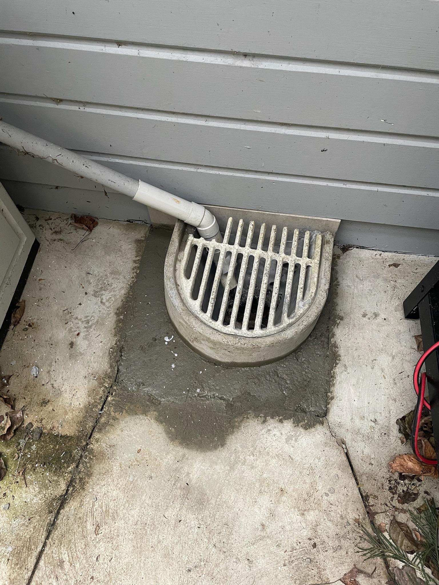 A nice clean concrete semi circle is now around the hole, with a grate over the top. All the pipes go in to the hole and there’s epoxy and concrete all around it to seal it off and make it nice.